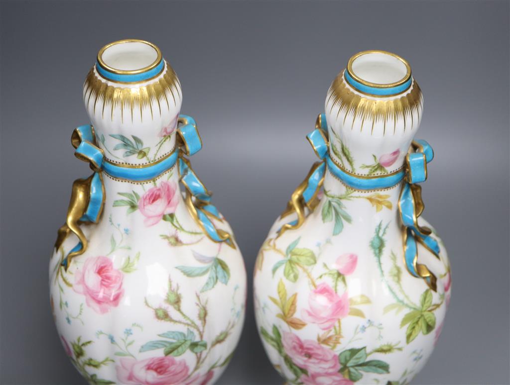 A pair of Minton style ovoid vases and covers, decorated with roses, 37cm